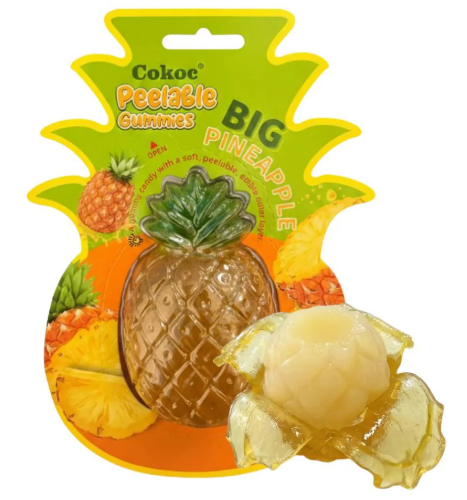 Cokoc Peelable Gummies Big Pineapple 150g – einzelner XXL-Ananas-Fruchtgummi in ananas-förmiger Blisterverpackung, daneben teilweise abgeschälte Schale mit Gummi-Ananas sichtbar